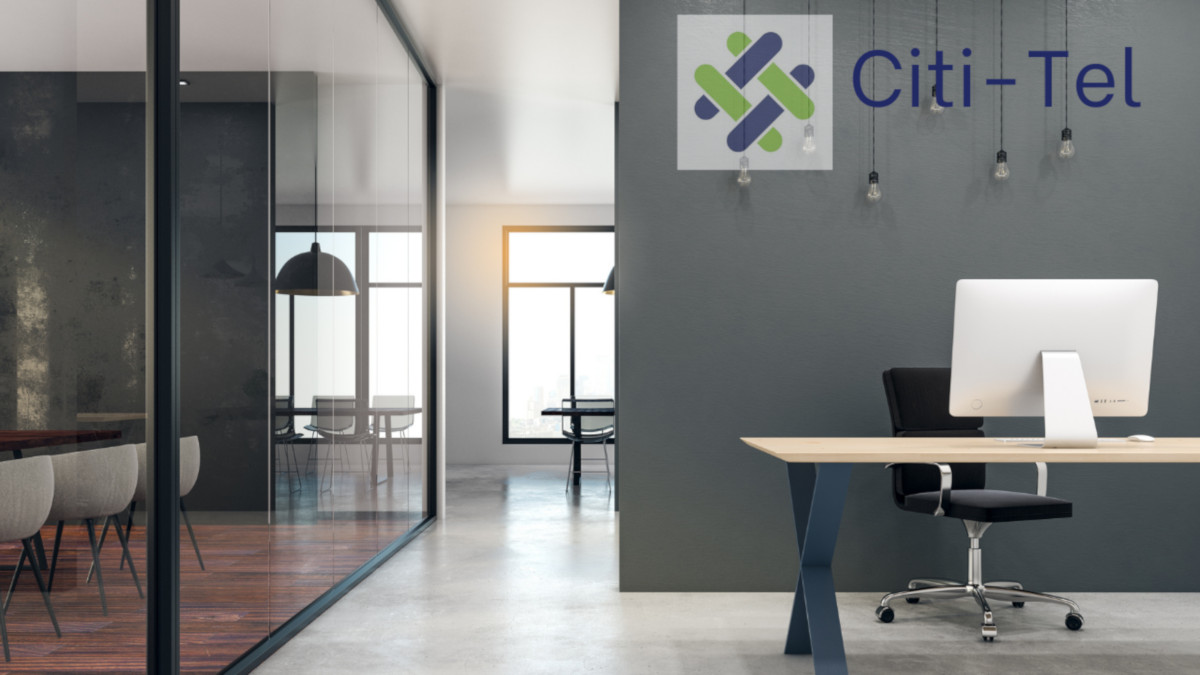 A modern office with a Citi-Tel Logo on a wall behind hanging lights