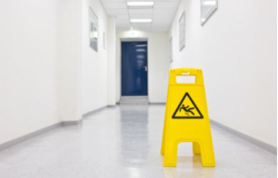 A yellow slippery surface sign in an office hallway