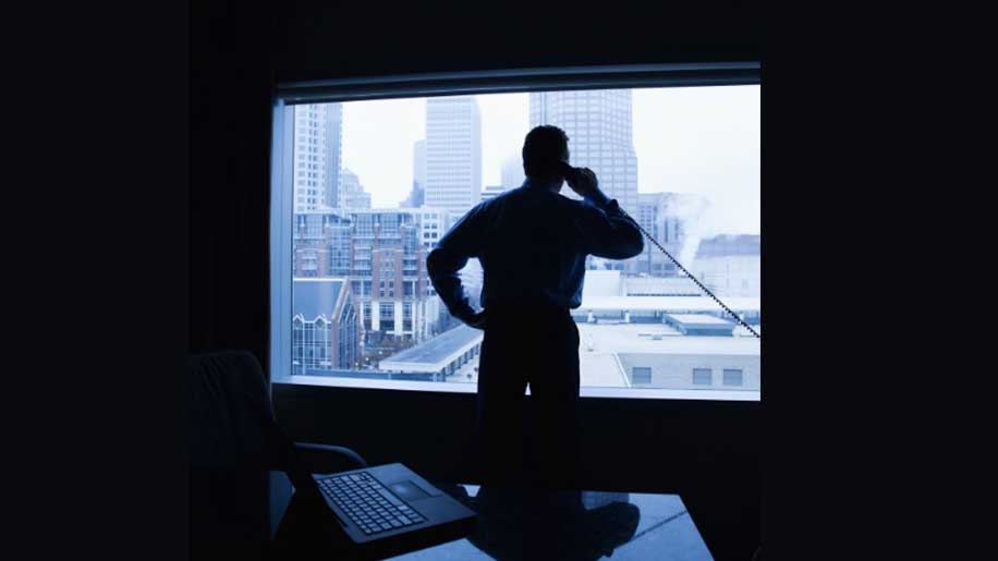 User on a phone looking out a window.