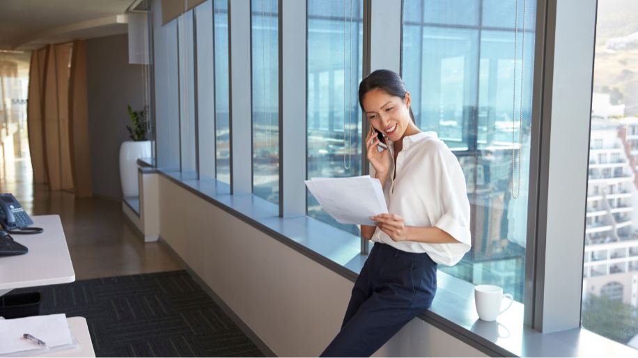 Woman talking on her phone while looking at papers